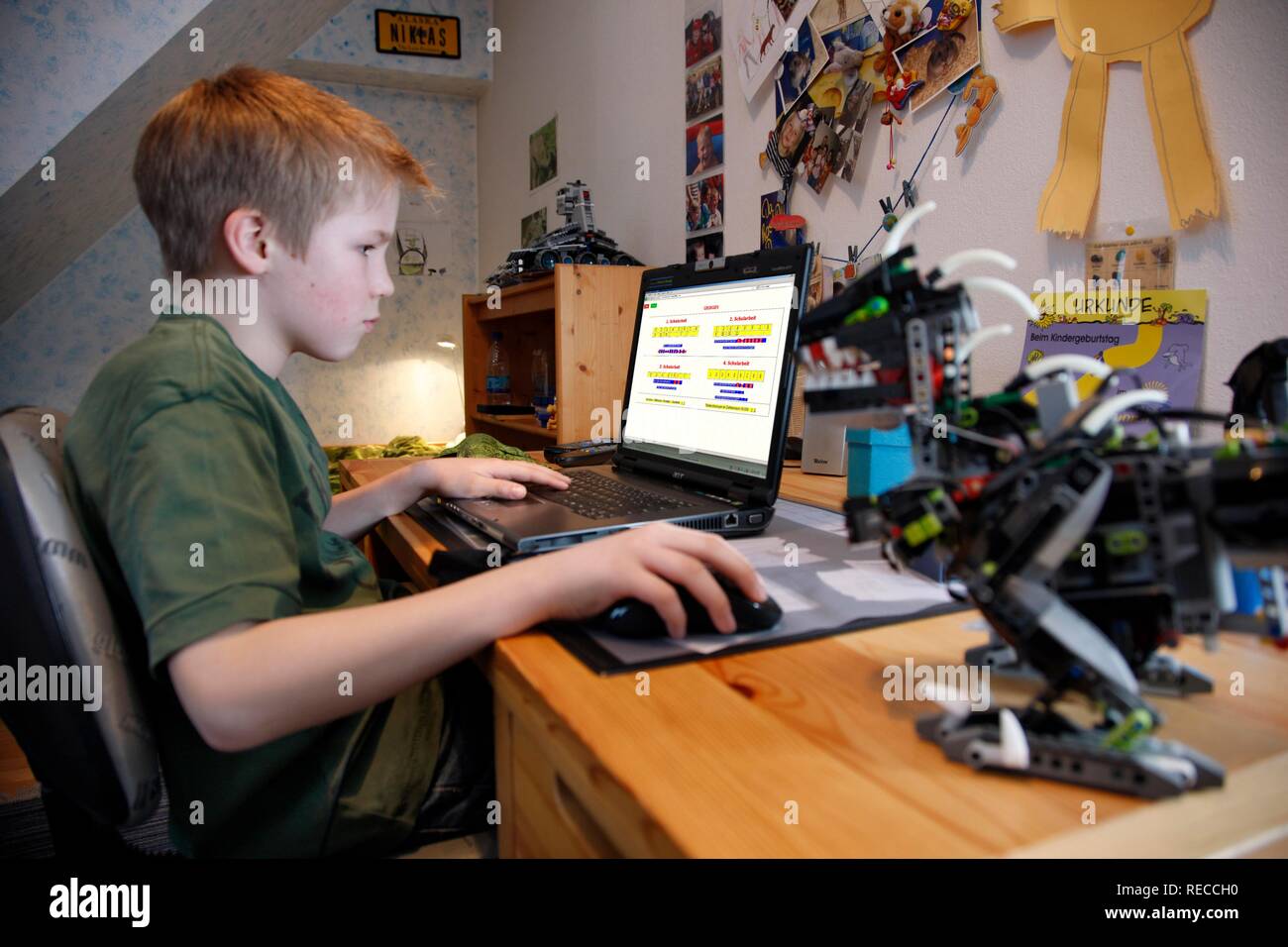 Garçon, 11, travaillant avec son ordinateur à la maison dans sa chambre à coucher à un bureau, de l'apprentissage pour l'école à l'aide d'un programme d'apprentissage en mathématiques Banque D'Images