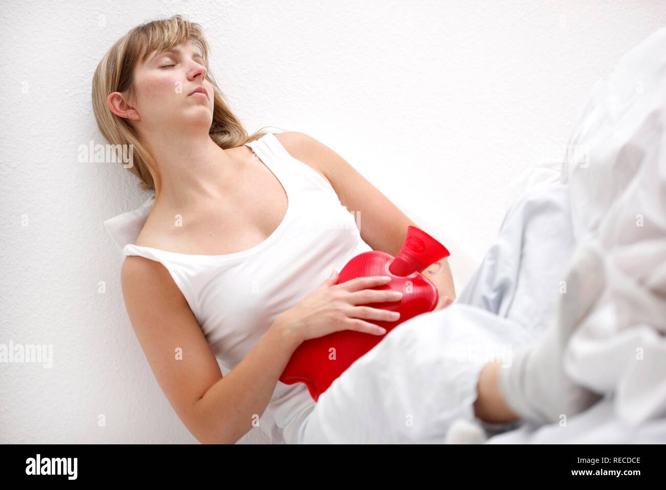 Femme a mal au ventre, la douleur avec un sac d'eau chaude, bouteille d'eau chaude Banque D'Images