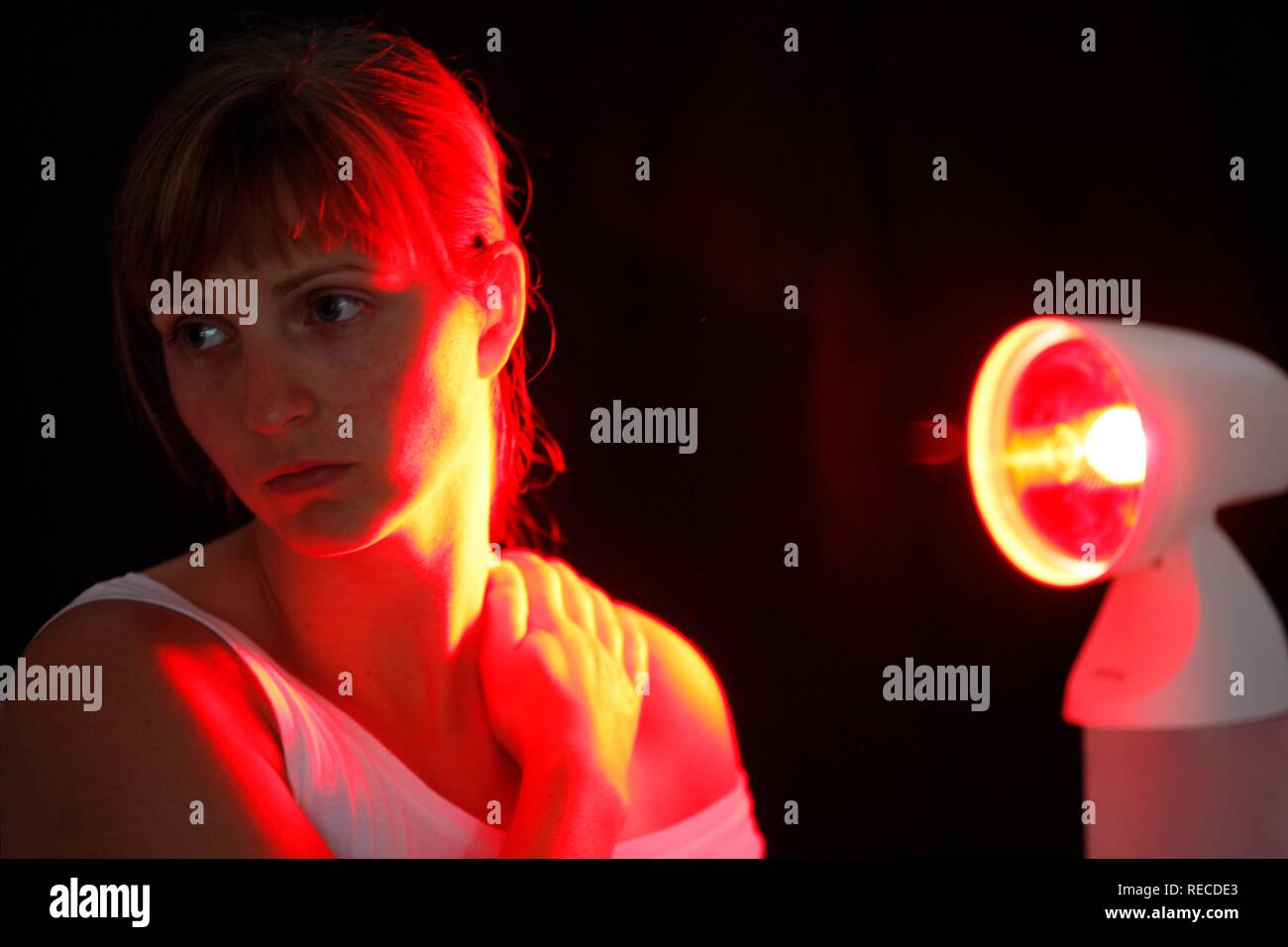 Jeune femme à l'aide d'une lampe UV, contre le rhume, la tension, la douleur Banque D'Images