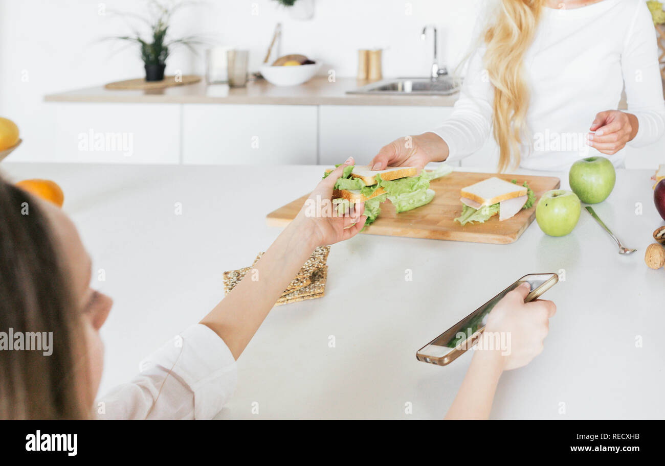 Concept de famille heureuse. Petit-déjeuner cuisine maman accueil de l'enfant dans la cuisine Banque D'Images