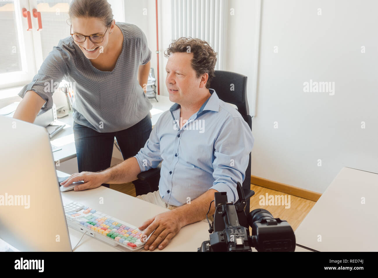 La femme et l'homme travaillant sur une vidéo en post-production Banque D'Images