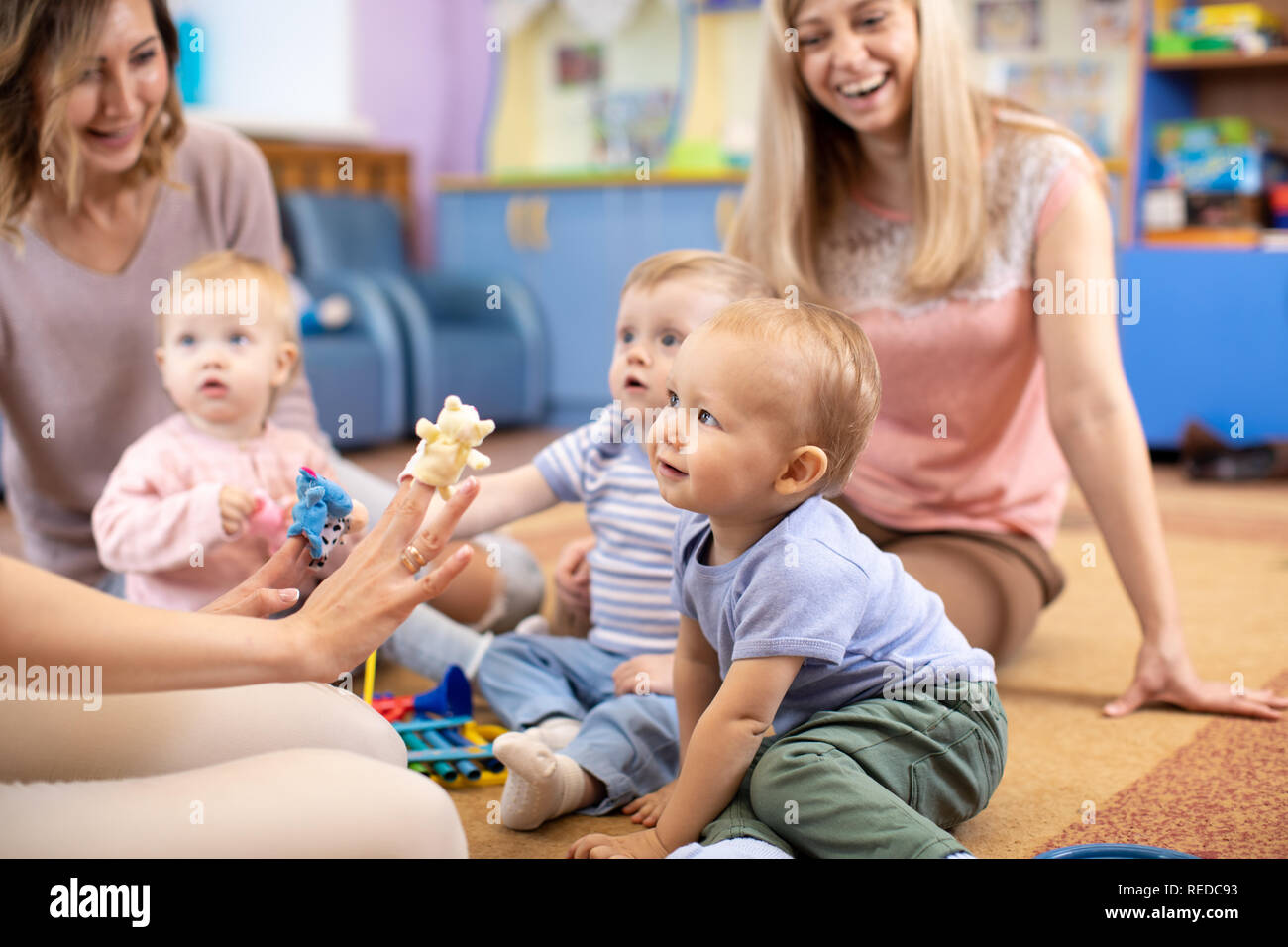 Professeur de français et des bébés jouant avec les jouets éducatifs en maternelle ou centre de jour Banque D'Images