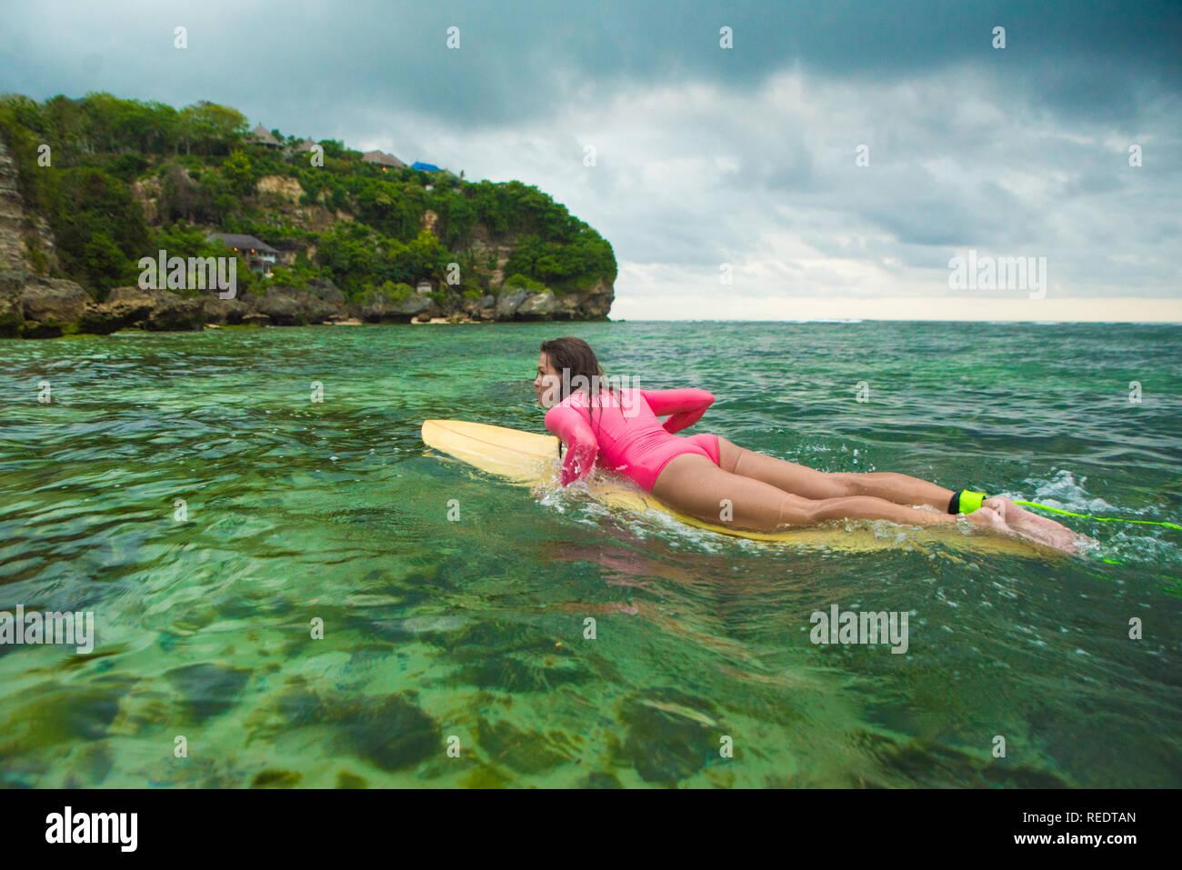 Belle femme nage sur une planche de surf. Banque D'Images