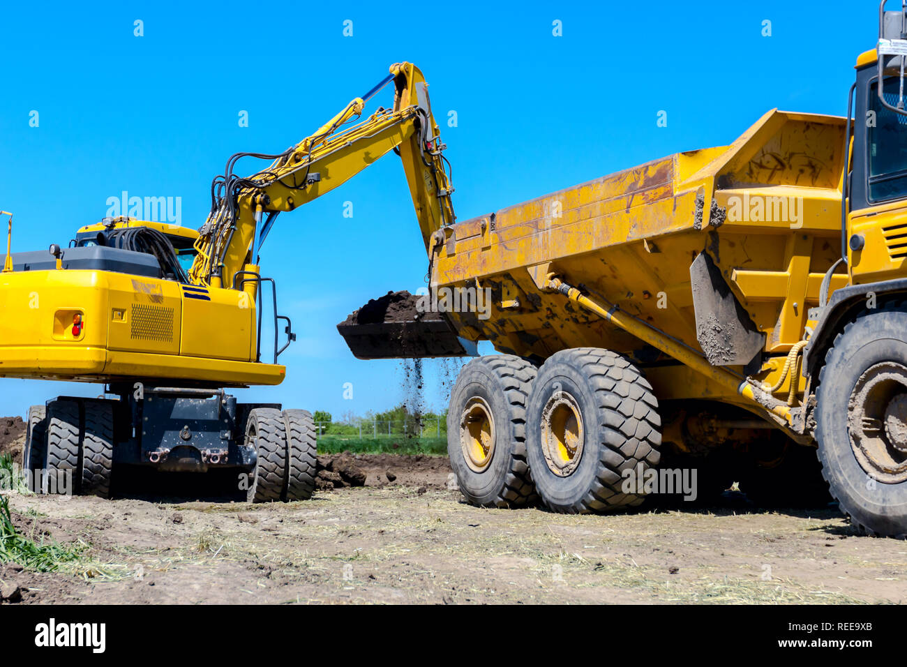 Grande pelle est de remplir un camion dumper avec sol au site de construction, projet en cours. Banque D'Images