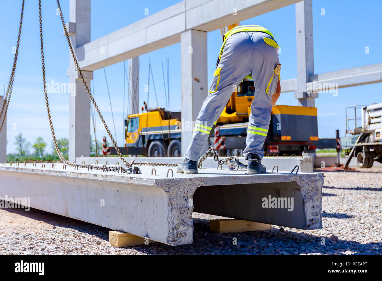 Gréeur est la fixation crochet de grue à la poutrelle en béton pour le levage de la structure d'assemblage. Banque D'Images