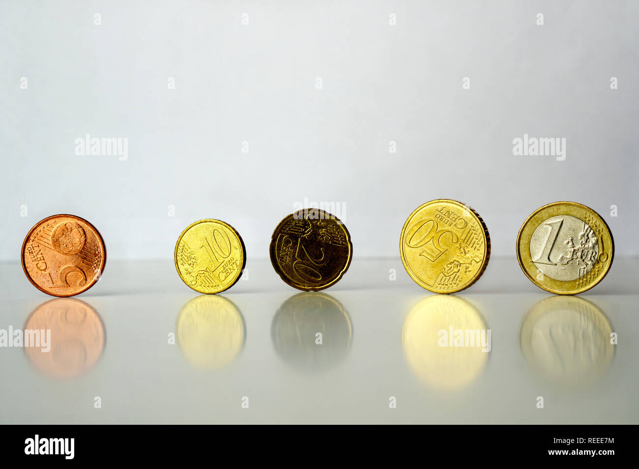 Comité permanent des pièces en euro cents sur fond gris avec reflet Banque D'Images