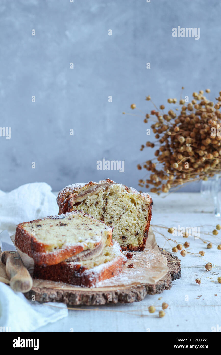 Tranches de gâteau sur un plateau en bois avec des fleurs séchées Banque D'Images