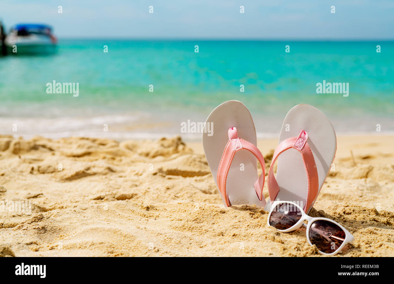 Sandales rose et blanche, des lunettes sur la plage de sable au bord de mer. Fashion style décontracté et flipflop lunettes à la mer. Vacances d'été on tropical beach. Banque D'Images
