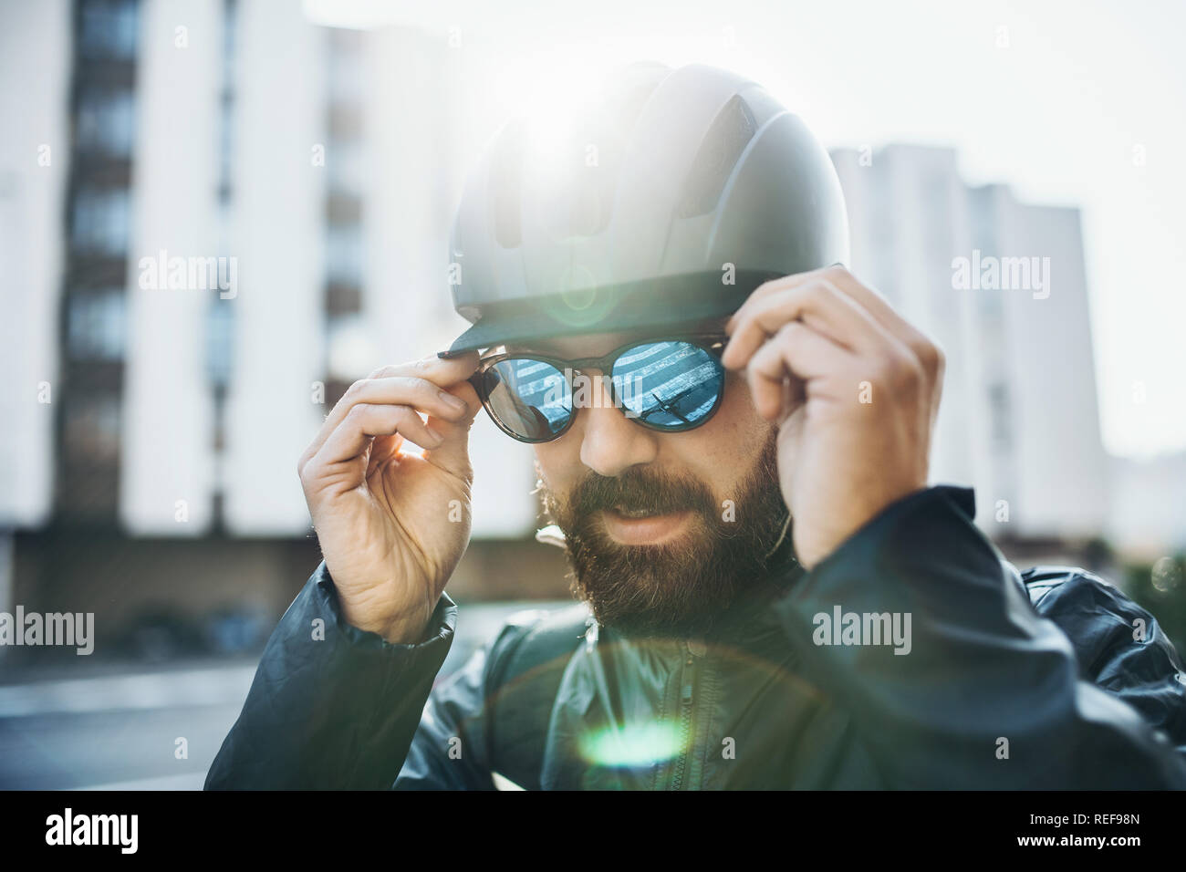 Homme location courier avec casque de mettre des lunettes de soleil dans la  ville Photo Stock - Alamy