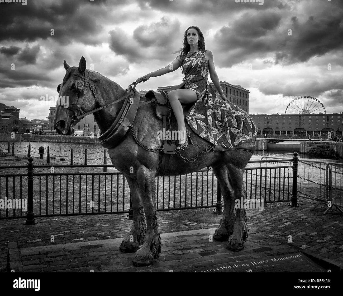 Photographie de mode de luxe d'un modèle de maturité sur une statue d'un cheval Banque D'Images