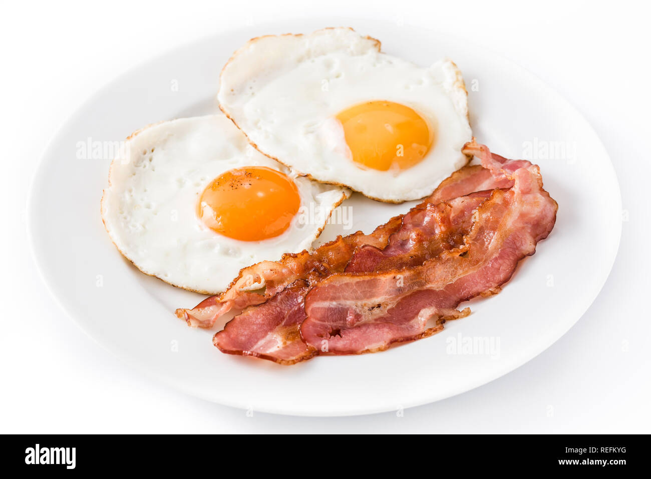 D'œufs au plat et du bacon pour le petit déjeuner isolé sur fond blanc. Close up Banque D'Images