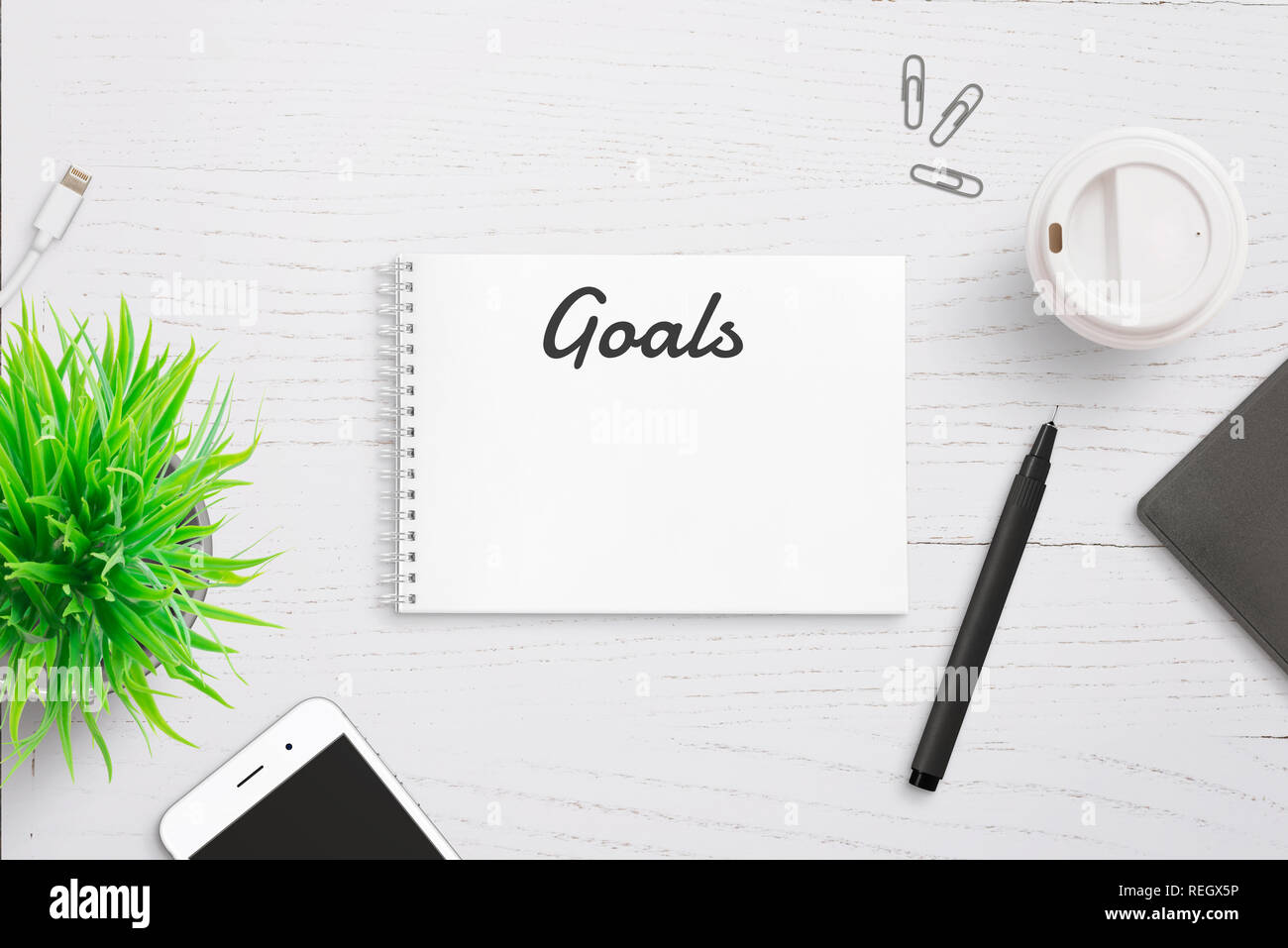 Texte sur le bloc-notes d'objectifs en-tête de page. Écrit annuel liste. Smart Phone, un crayon et du café à côté. Banque D'Images