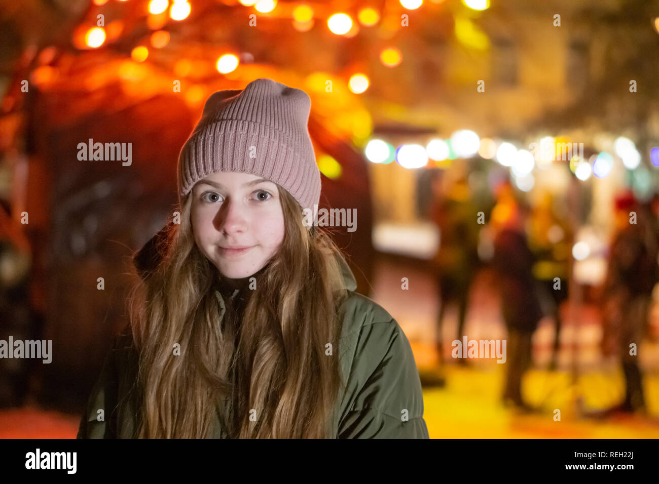 Belle fille à la recherche vers le bas sur la rue de la ville de nuit sur la toile de fond avec devanture rougeoyant. bokeh. L'espace de copie de l'inscription ou d'objets Banque D'Images