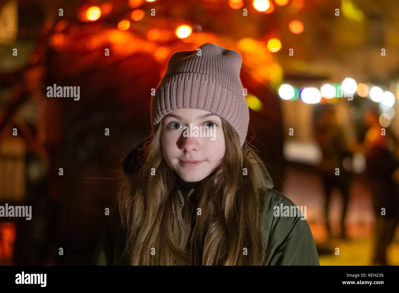 Belle fille à la recherche vers le bas sur la rue de la ville de nuit sur la toile de fond avec devanture rougeoyant. bokeh. L'espace de copie de l'inscription ou d'objets Banque D'Images