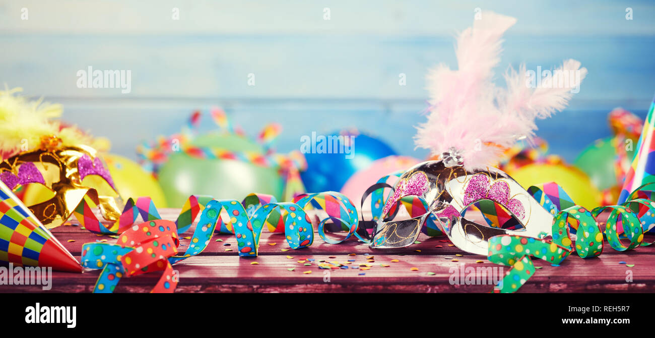 Carnaval haut en couleurs avec bannière panoramique un fatras de partie des ballons, banderolles, chapeaux coniques et les confettis sur une table en bois avec copie espace Banque D'Images
