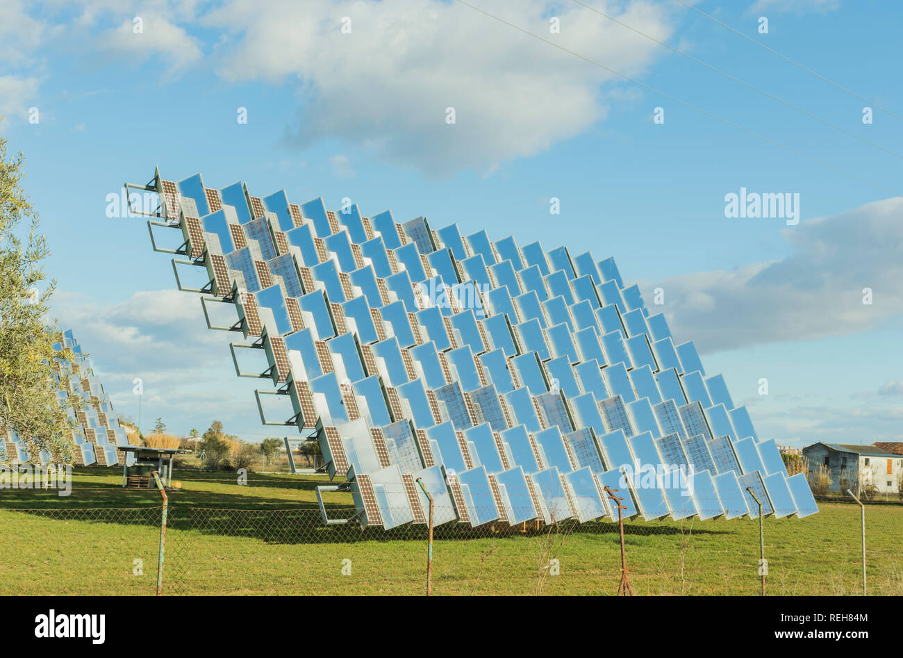 Panneau solaire photovoltaïque dans un verger solaire, vu d'un côté sur un champ vert Banque D'Images