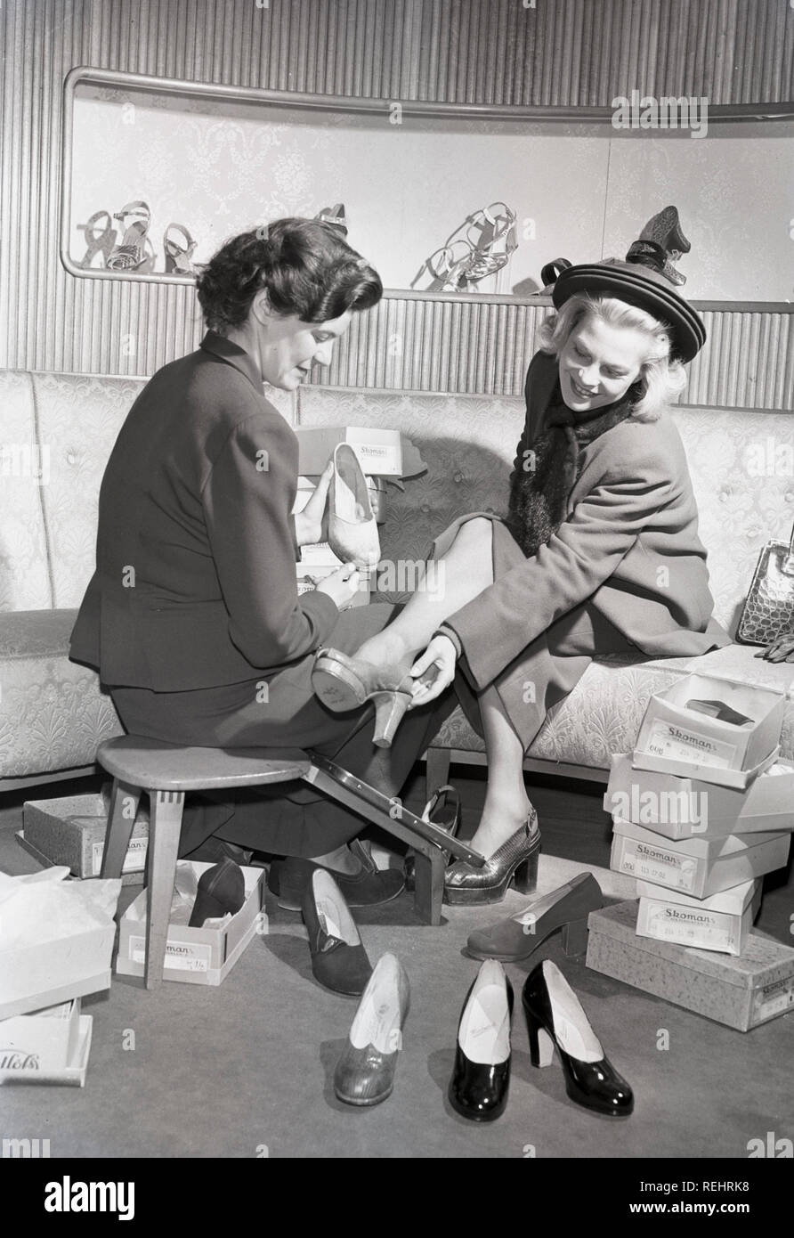 Shopping dans les années 40. Une jeune femme blonde dans un magasin de  chaussures pour femmes