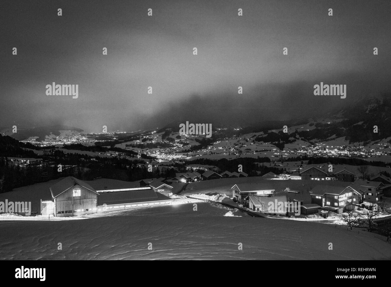 La photographie de nuit long exposé les voitures qui circulent dans une route de montagne enneigée dans les Alpes d'Autriche. Banque D'Images