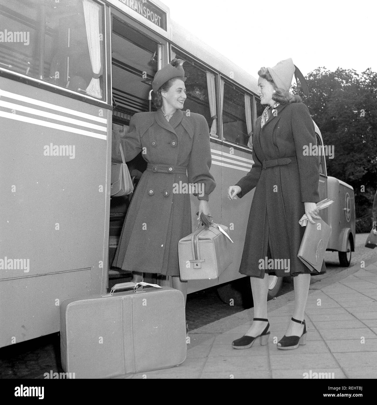 La mode féminine dans les années 40. Une jeune femme en robe typique des années 40, avec chapeau assorti, chaussures, gants et sac à main. Elle descend du bus transportant ses bagages et est accueilli par une amie aussi dans un typique des années 40. Kristoffersson Photo Ref V77-4. Suède 1947 Banque D'Images
