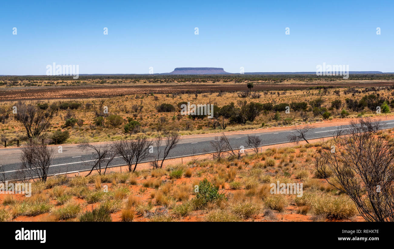 Vue éloignée sur le Mont Conner avec Lasseter Highway dans NT outback Australie centrale Banque D'Images