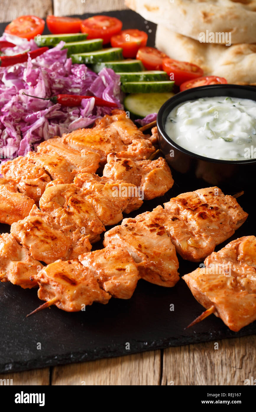 Délicieux Arabian Taouk brochettes de poulet avec légumes frais, sauce yogourt et pita close-up sur la table verticale. Banque D'Images