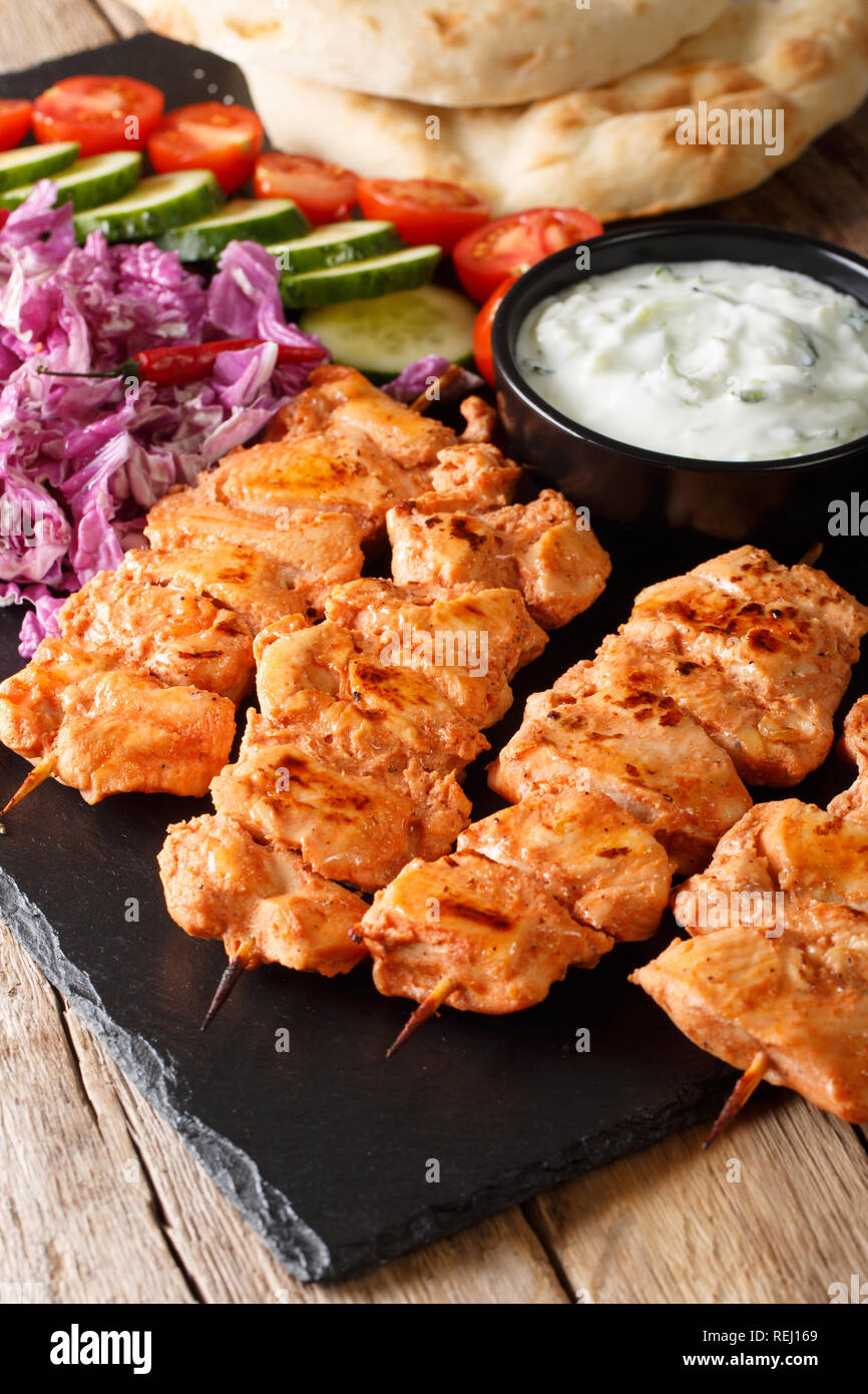 Taouk libanais brochettes de poulet servi avec des légumes frais, sauce et pita close-up sur la table verticale. Banque D'Images