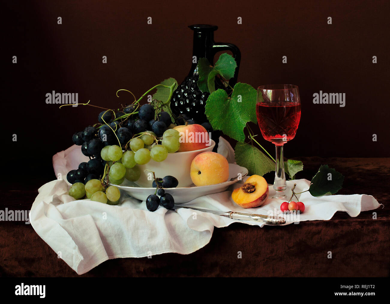 Vin rouge avec des fruits sur une nappe blanche Banque D'Images