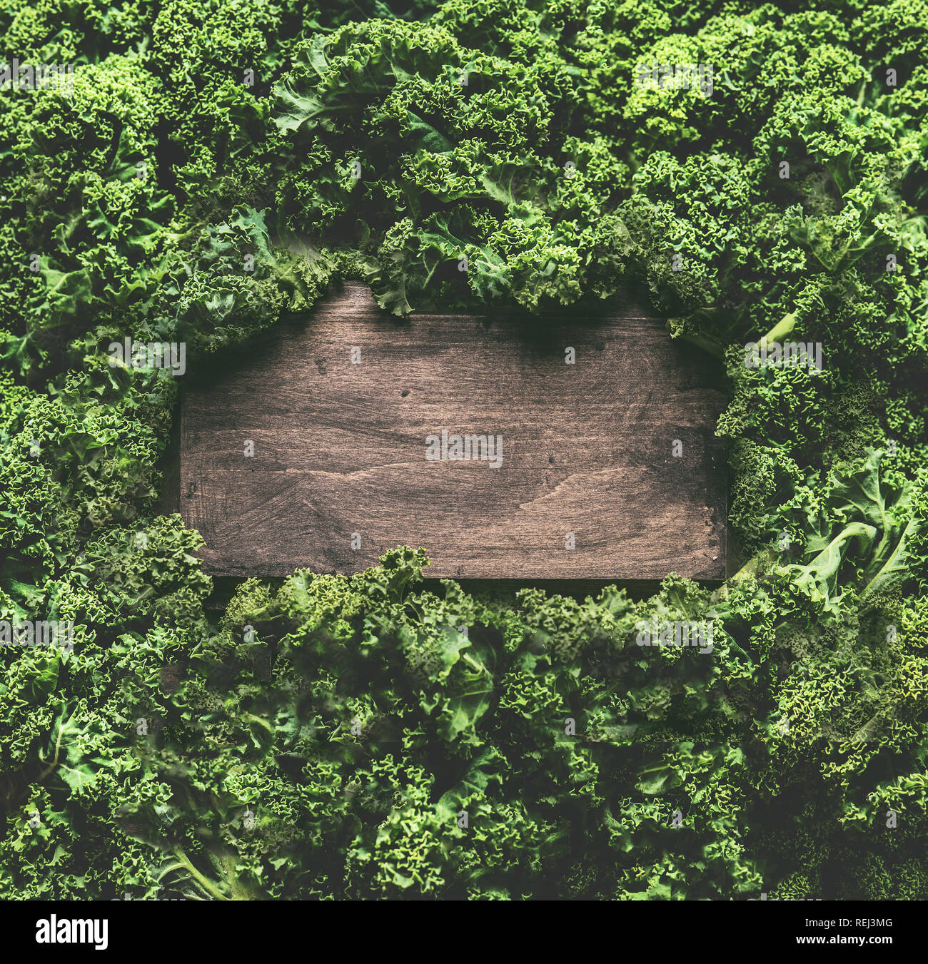 Feuilles de chou contexte cadre avec panneau en bois. Detox saine des légumes . Manger et suivre un régime propre concept. Vue de dessus avec l'exemplaire de l'espace. Recettes et Kale Banque D'Images