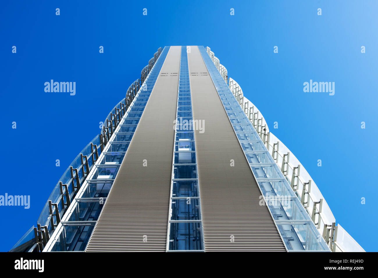 Low angle de vue d'un gratte-ciel moderne avec revêtement décoratif externe sur les murs latéraux contre un ciel bleu ensoleillé Banque D'Images