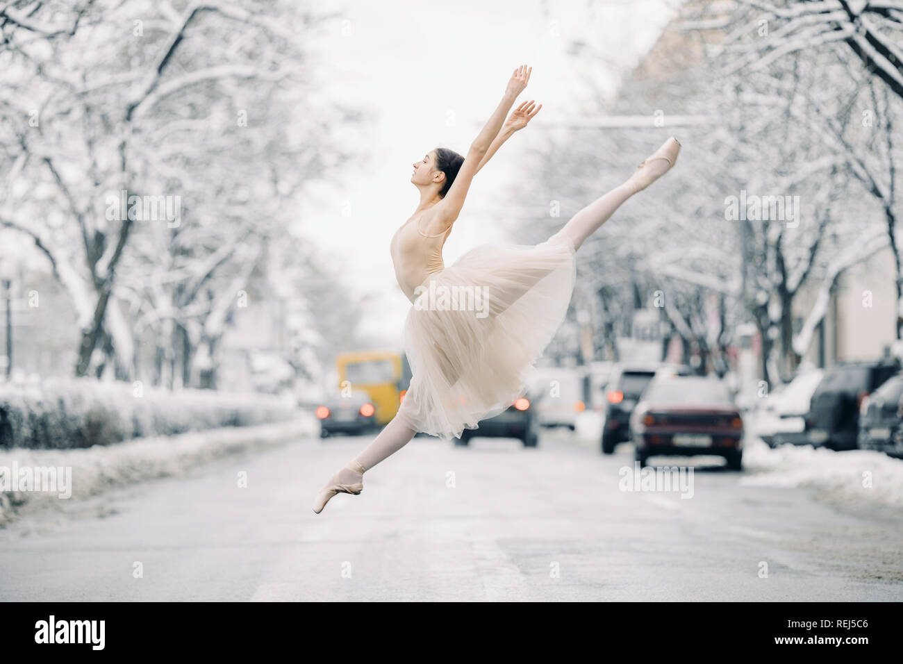 Belle jupe transparente en ballerine danse et de sauter sur la rue de snowy  city parmi les voitures Photo Stock - Alamy