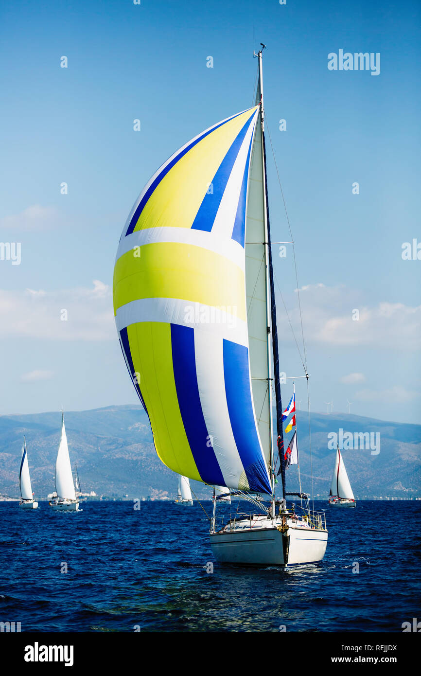Yacht de luxe avec des voiles de régate à la couleur. La Voile dans le vent à travers les vagues à la mer. Banque D'Images