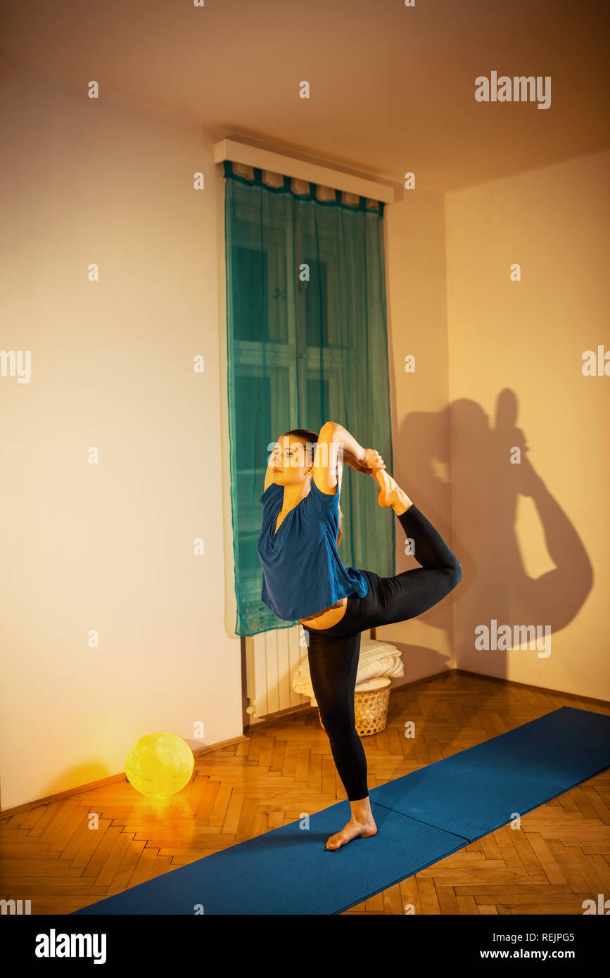 Jeune yogi attractive woman practicing yoga concept, debout dans l'exercice Natarajasana, Seigneur de la danse, de l'exercice, portant des vêtements de sport,. Ton Banque D'Images