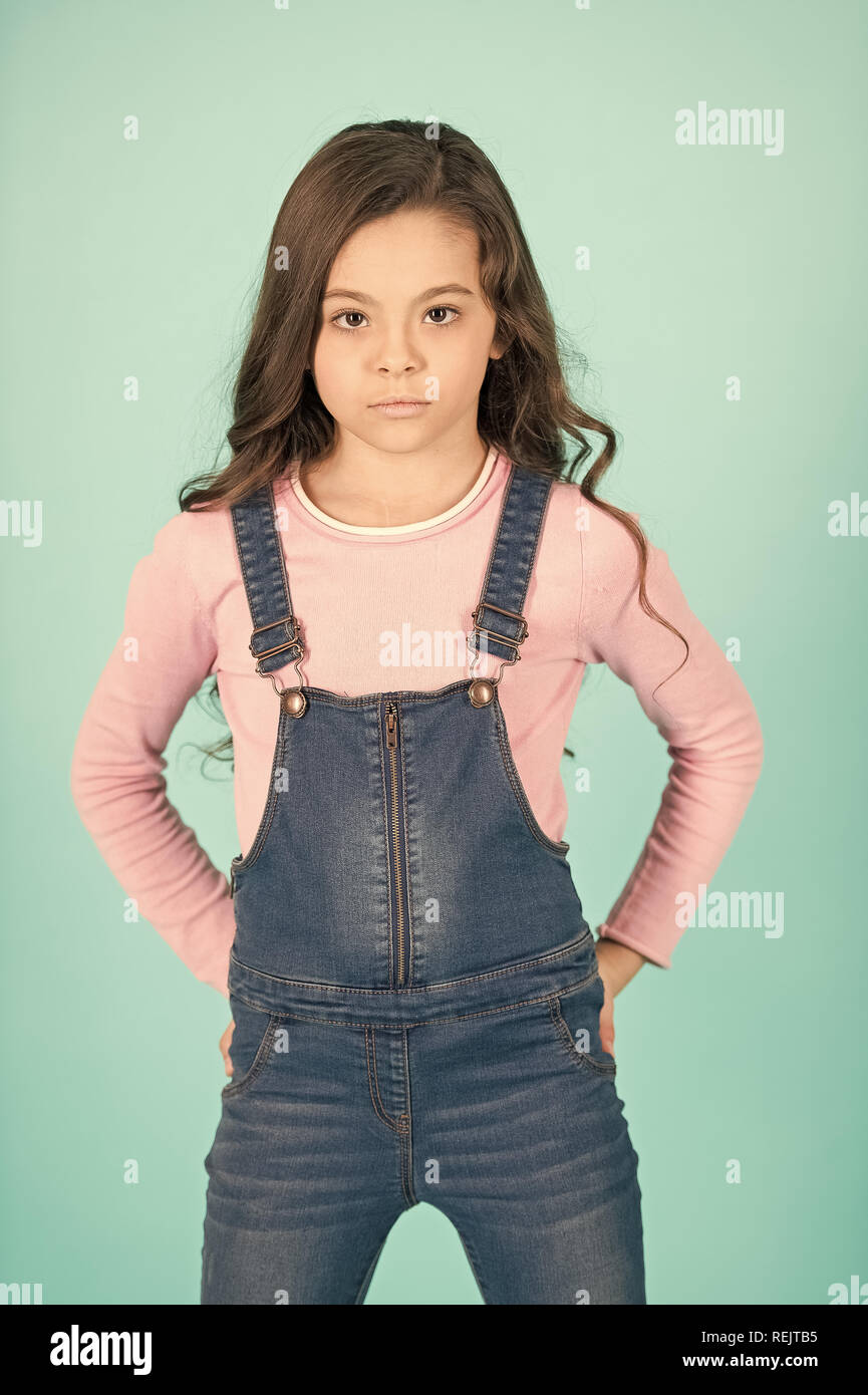 Kid fashion, style décontracté. Petite fille de poser dans l'ensemble de  jeans, mode. Enfant avec de longs cheveux de brunette, la beauté. Beauté,  look, coiffure. L'enfance, la jeunesse punchy tendance pastel Photo