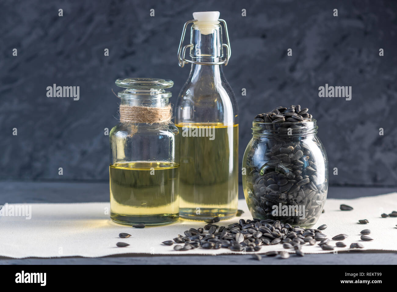 Les graines de tournesol dans un tas d'or et de l'huile dans une bouteille en verre sur la table. Concept alimentation saine avec des graisses végétales. Banque D'Images