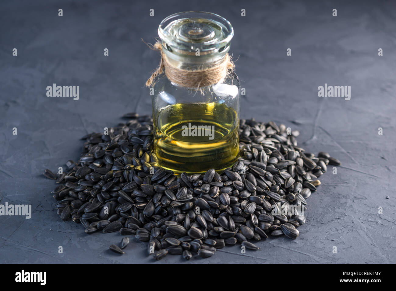 Les graines de tournesol dans un tas d'or et de l'huile dans une bouteille en verre sur la table. Concept alimentation saine avec des graisses végétales. Banque D'Images