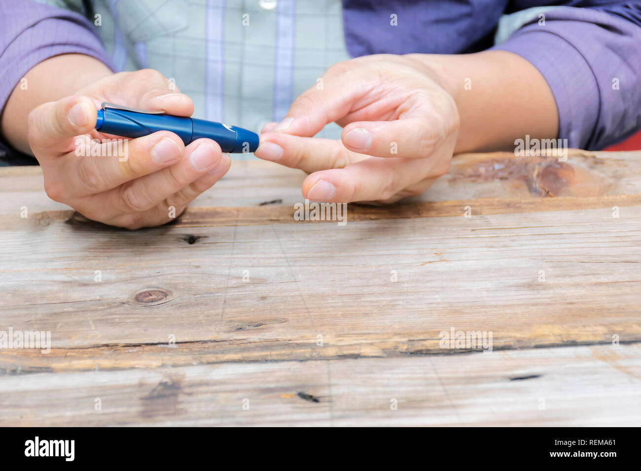 L'homme de prendre échantillon de sang avec lancette stylo. Concept du diabète. La médecine, le diabète, la glycémie, les soins de santé et les personnes - close up à l'aide d'amphioxus sur doigt pour Banque D'Images
