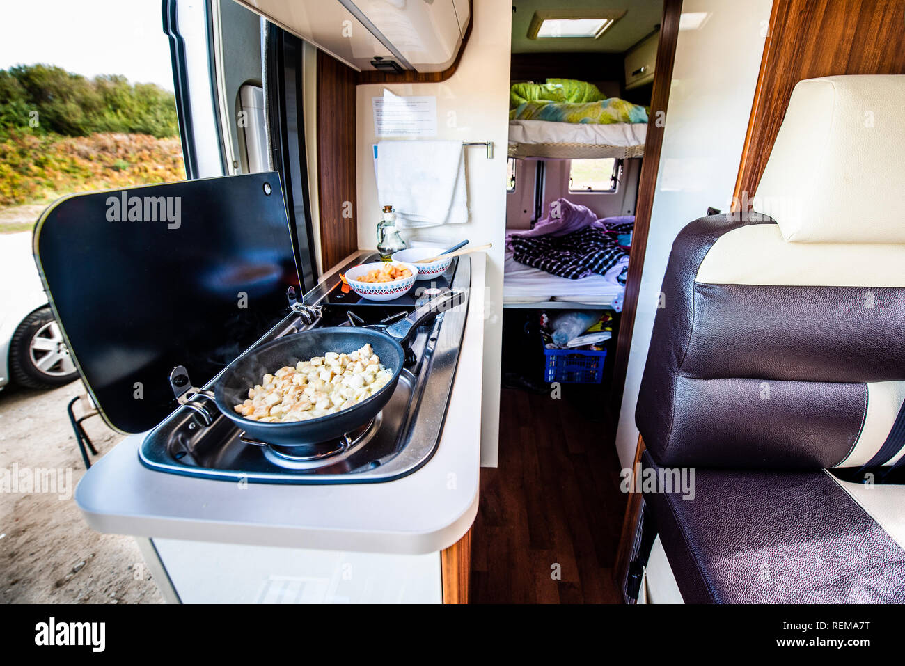 Cuire le dîner ou déjeuner dans un camping-car, camping-car ou camping. La préparation de poulet dans une casserole dans le camping-car lorsque vous voyagez avec RV, autocaravane caravane ou motorva Banque D'Images