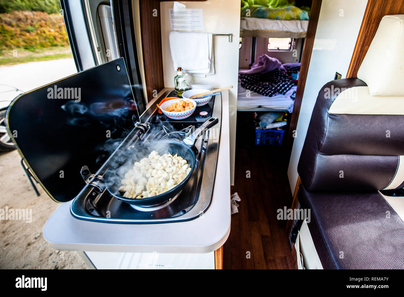 Cuire le dîner ou déjeuner dans un camping-car, camping-car ou camping. La préparation de poulet dans une casserole dans le camping-car lorsque vous voyagez avec RV, autocaravane caravane ou motorva Banque D'Images
