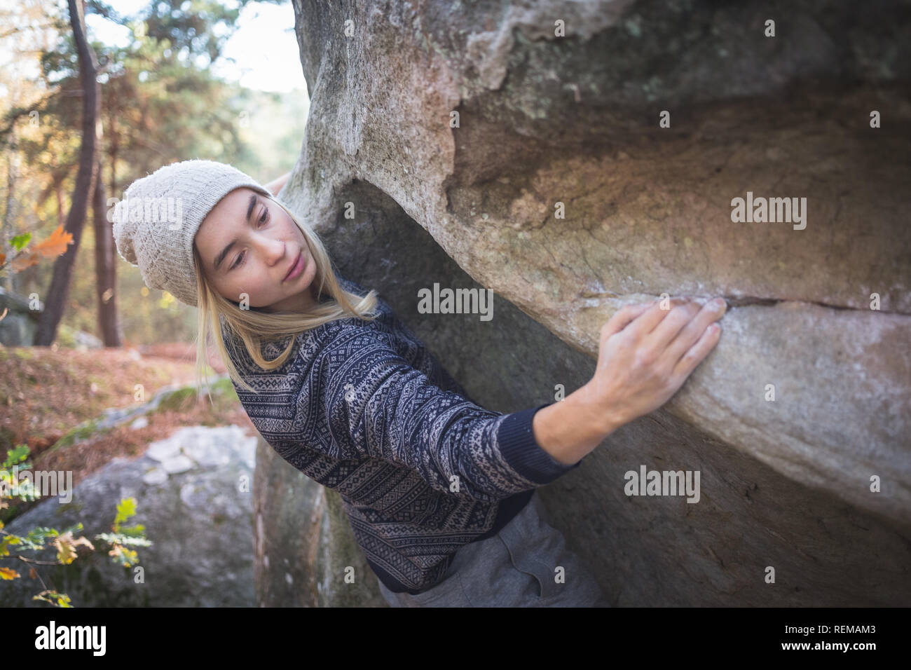 Une jeune femme seule, le bloc d'escalade dans la forêt de Fontainebleau, France. Banque D'Images