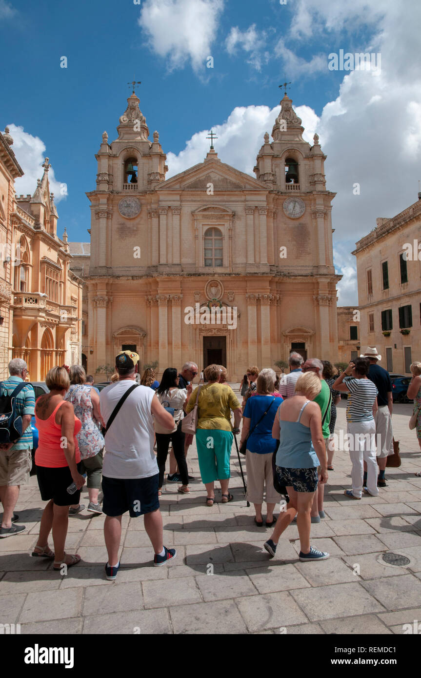 Un groupe de touristes d'admirer la façade de la Cathédrale St Paul à l'ancienne ville de Mdina à Malte. Banque D'Images