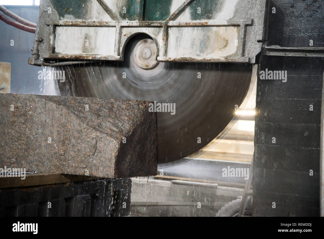 La transformation de granit dans la fabrication. Plaque de granit de coupe avec une scie circulaire. Banque D'Images