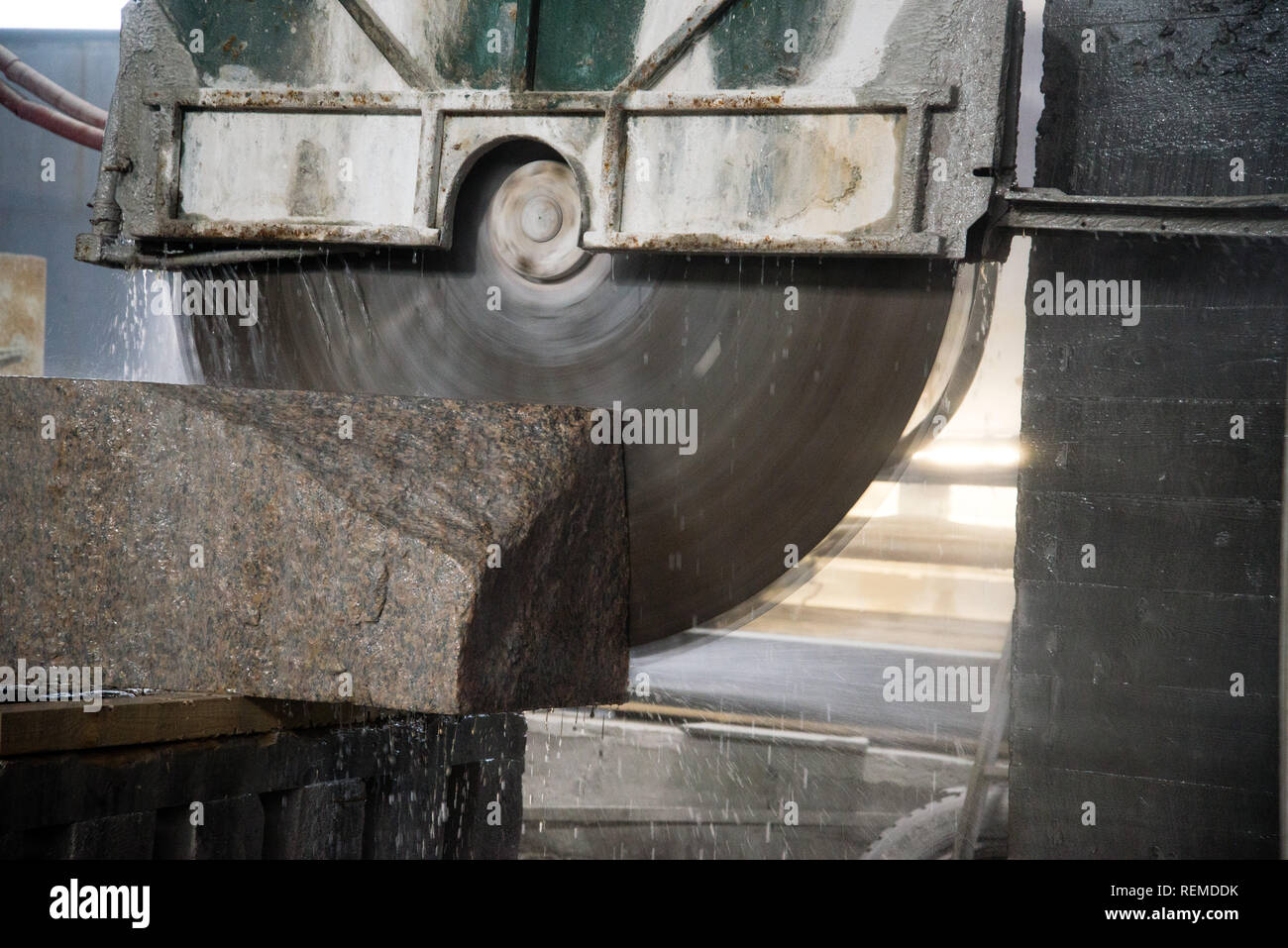 La transformation de granit dans la fabrication. Plaque de granit de coupe avec une scie circulaire. Banque D'Images