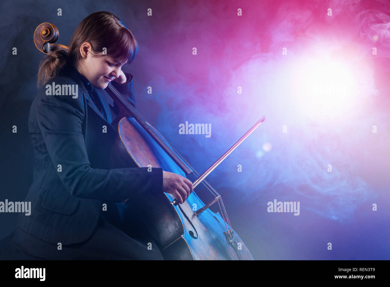 Close-up de la violoncelliste jouant la musique classique au violoncelle. Le brouillard à l'arrière-plan. Studio shot Banque D'Images