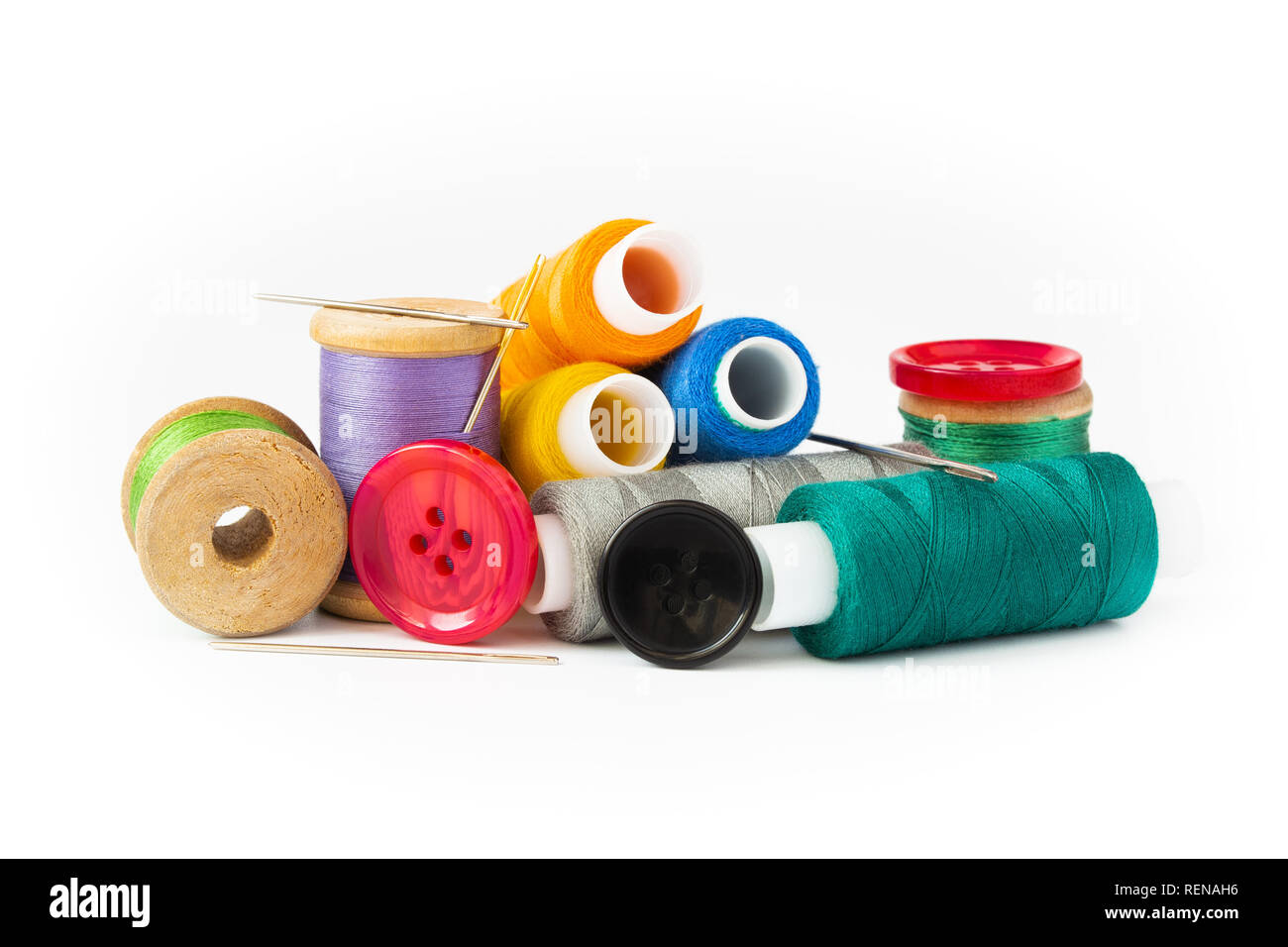 Couleur multi-threads sur bobines et rouleaux. Aiguilles et boutons. Sur un fond blanc. Banque D'Images