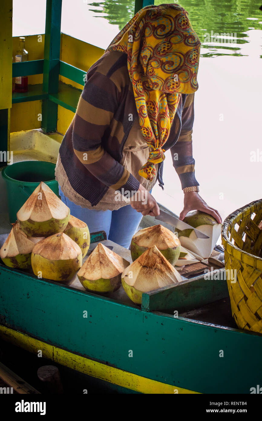 Couper une femme en bonne forme de noix de coco et servir pour une nouvelle boisson naturelle Banque D'Images