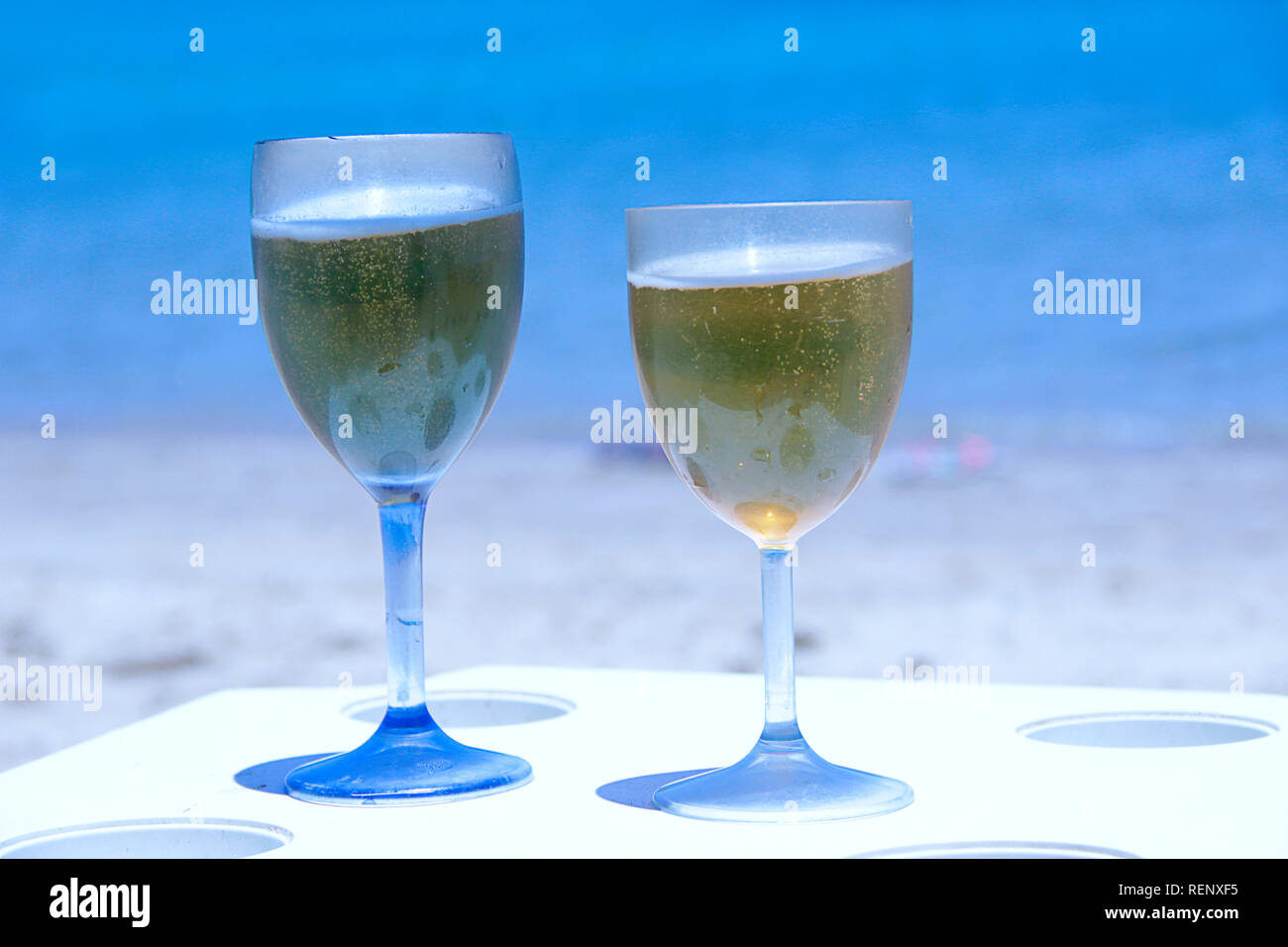 Deux verres de bière par la mer. Des bières fraîches dans des verres sur la table de resort sur la côte de l'océan. Bénéficiant d'autres tropicales. Deux verres de bière sur la plage. Un froid Banque D'Images