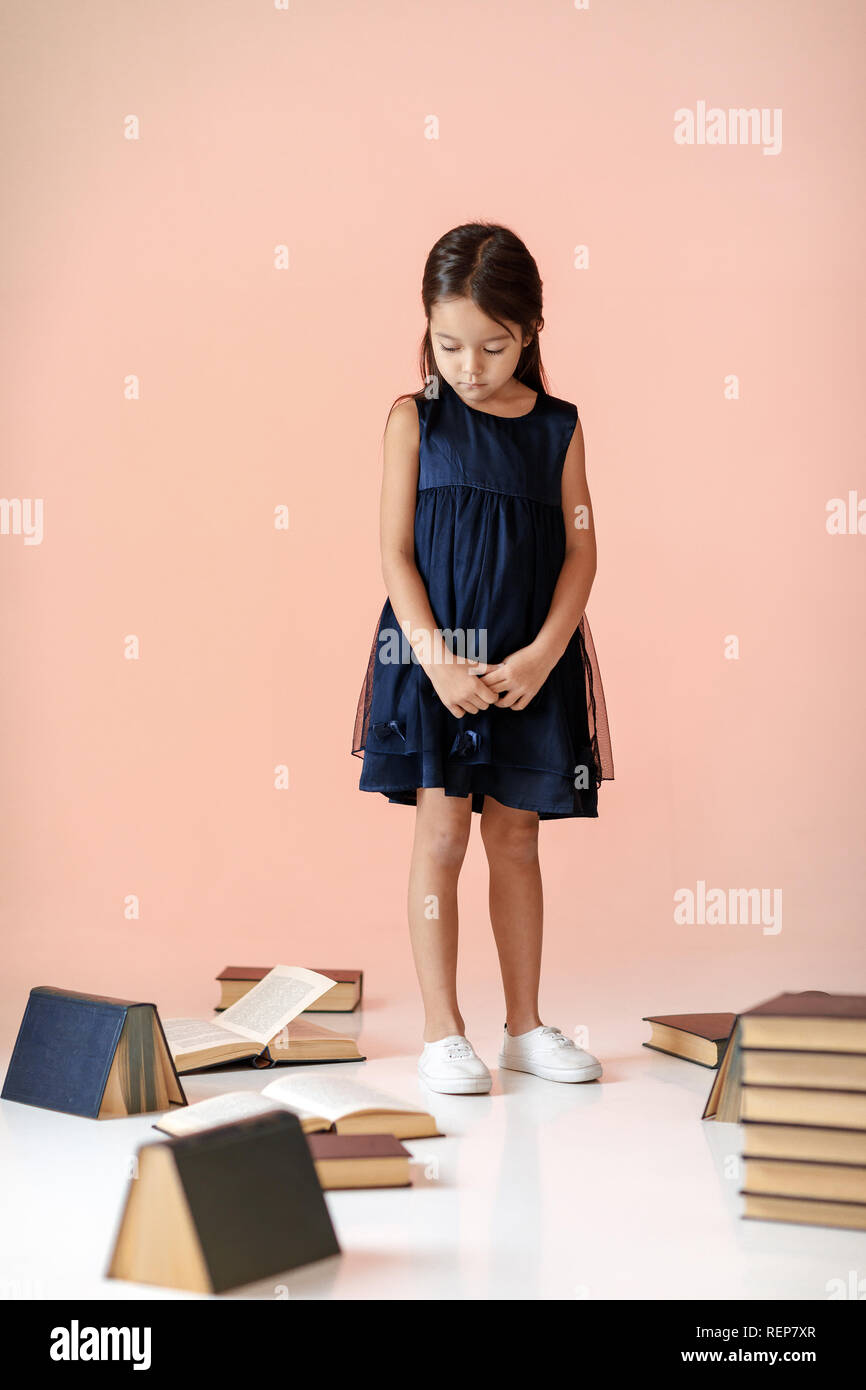 Cute little girl est en train de lire un livre. Banque D'Images