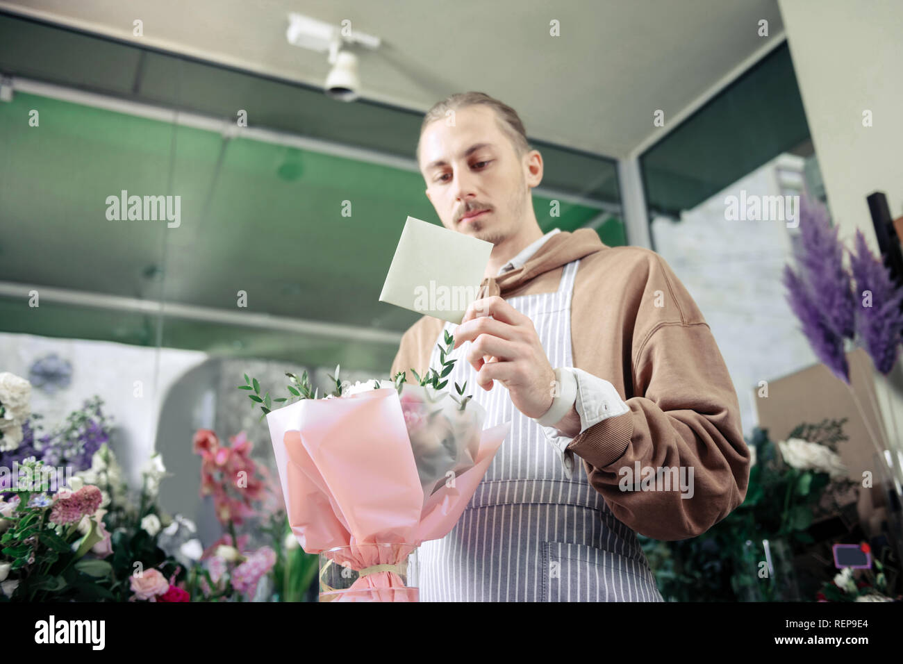 Bel homme blond notes de lecture au travail Banque D'Images