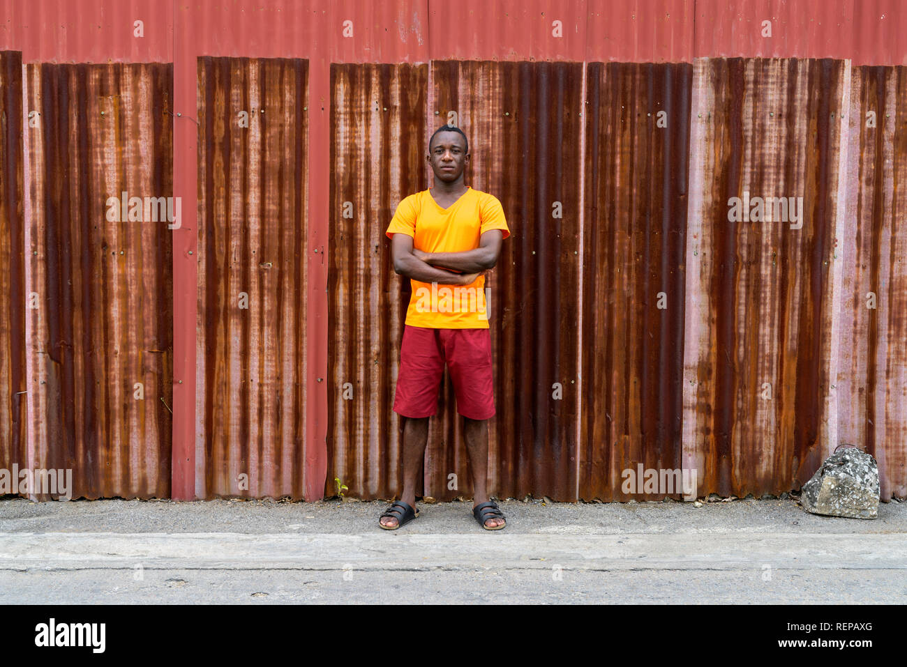 Les jeunes d'Afrique noire homme debout avec les bras croisés contre l'ancienne r Banque D'Images