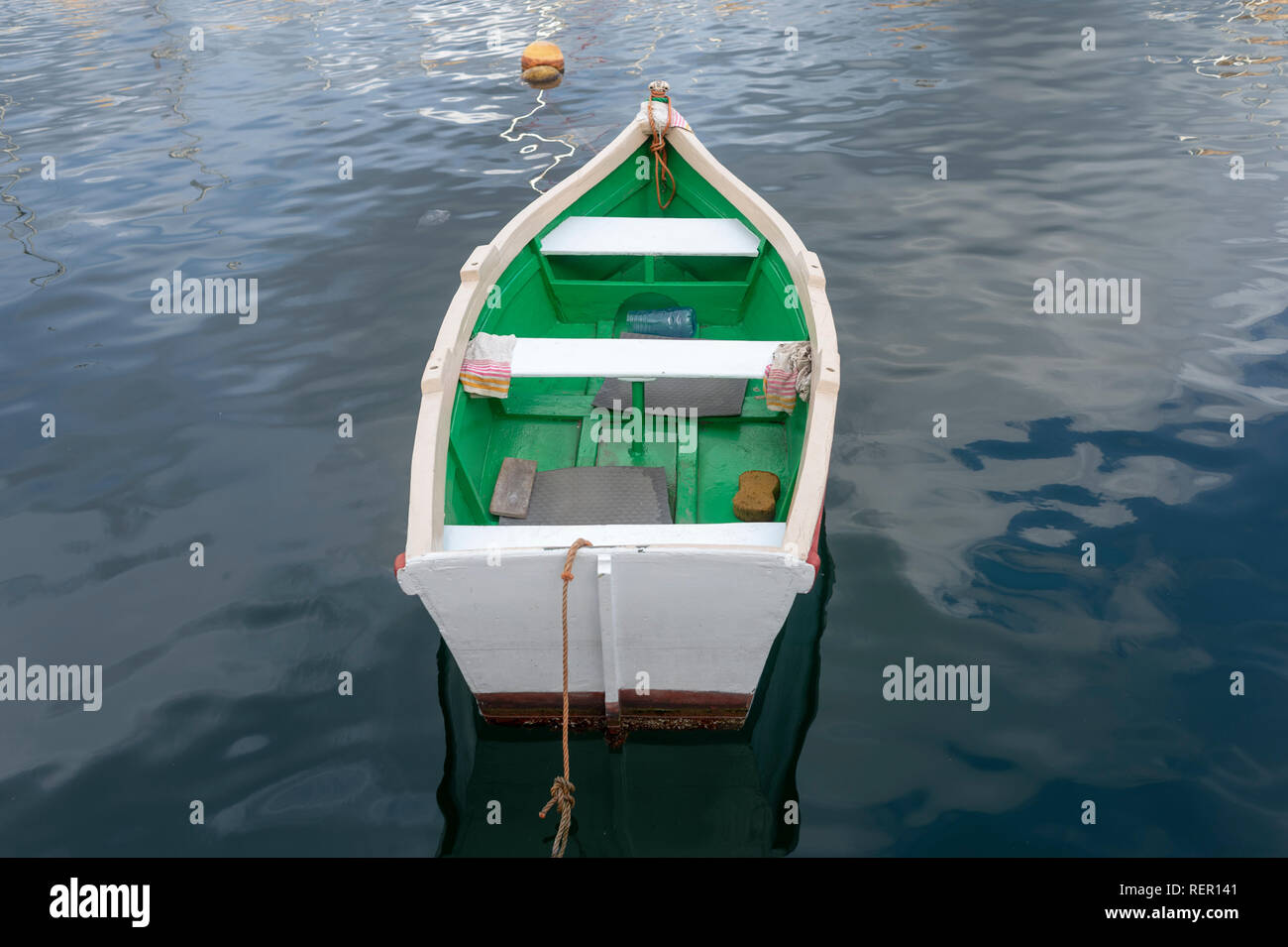 Blanc et vert petit bateau à rames amarrés dans l'eau calme, La Valette, Malte Banque D'Images